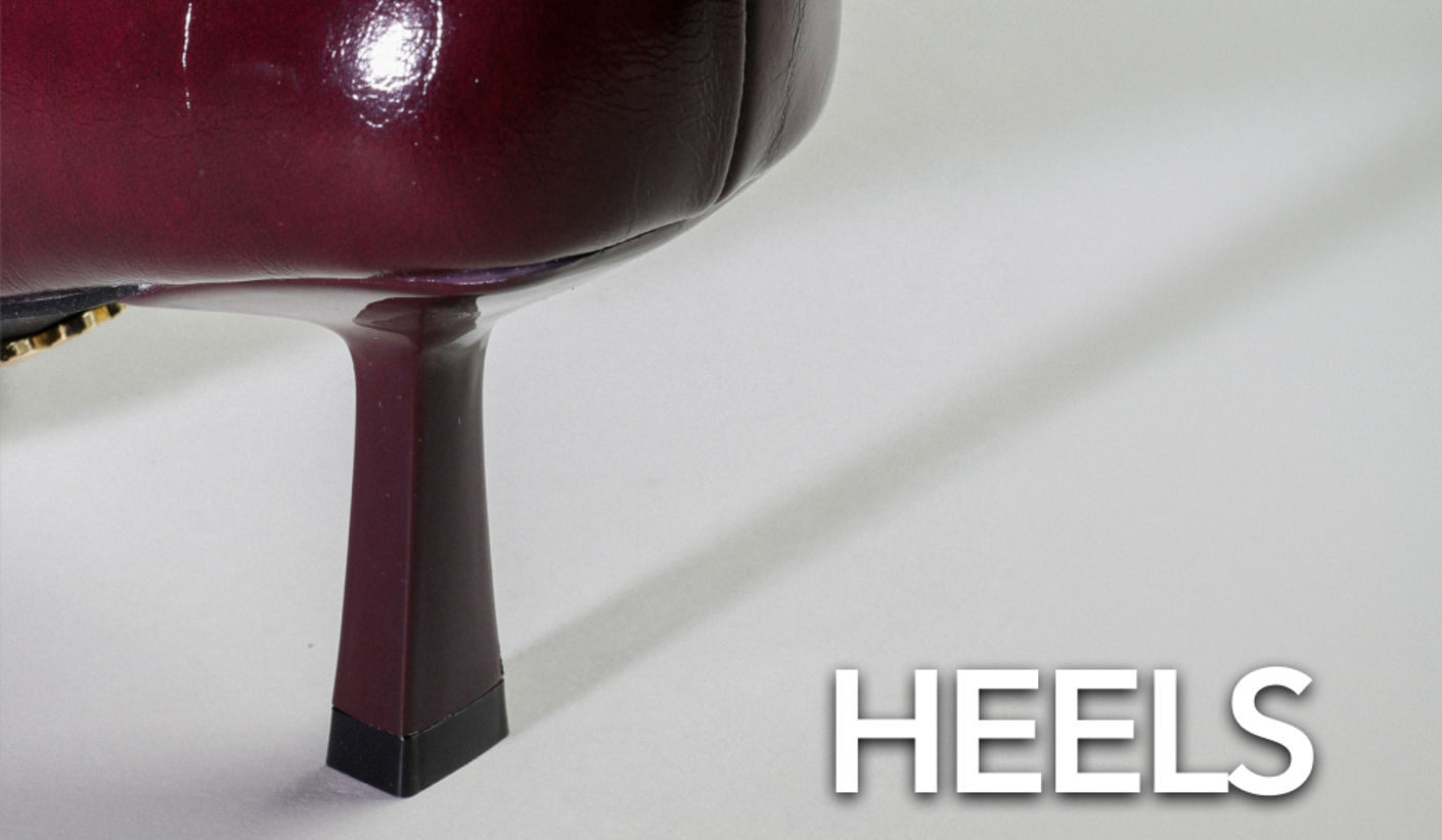 Close-up of a glossy burgundy high heel with a sculpted heel shape on a light background, alongside the text “HEELS”.