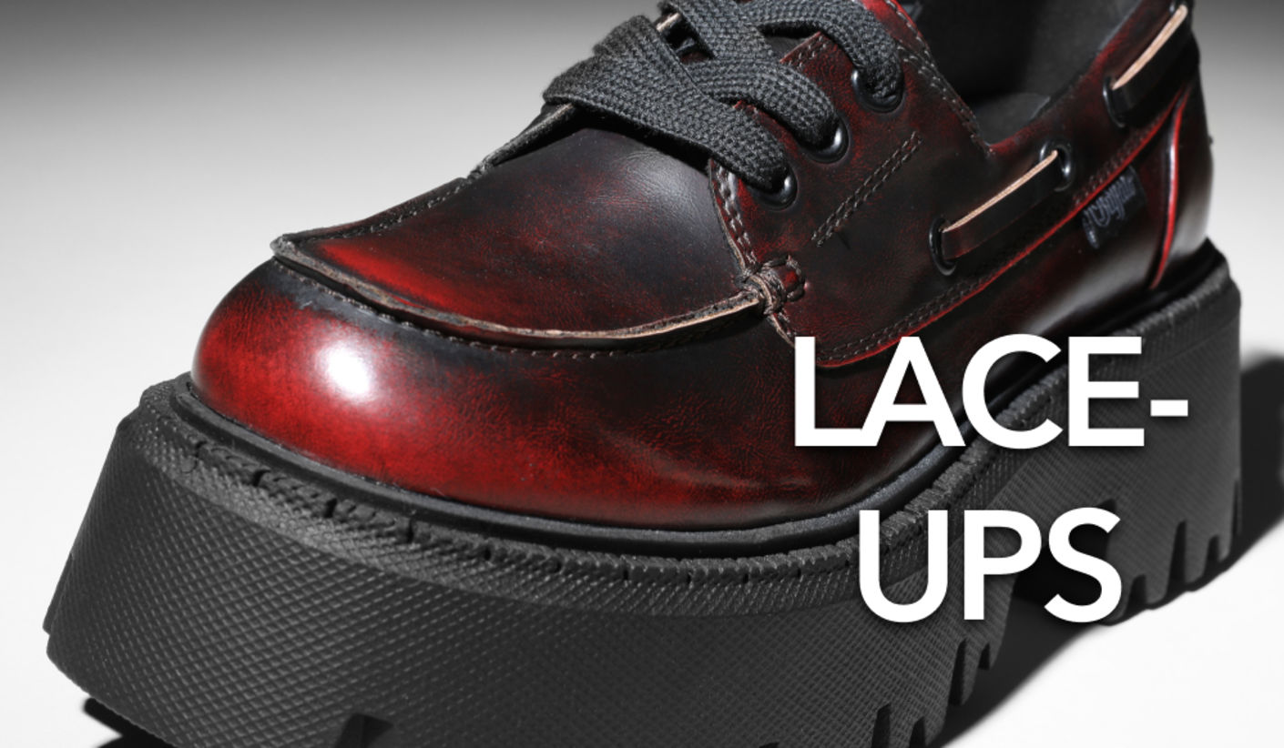 Close-up of a glossy red and black lace-up shoe with a chunky platform sole and black laces, alongside the text “LACE-UPS”.