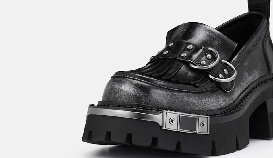 Close-up of black BUFFALO platform loafer with metal buckle details.