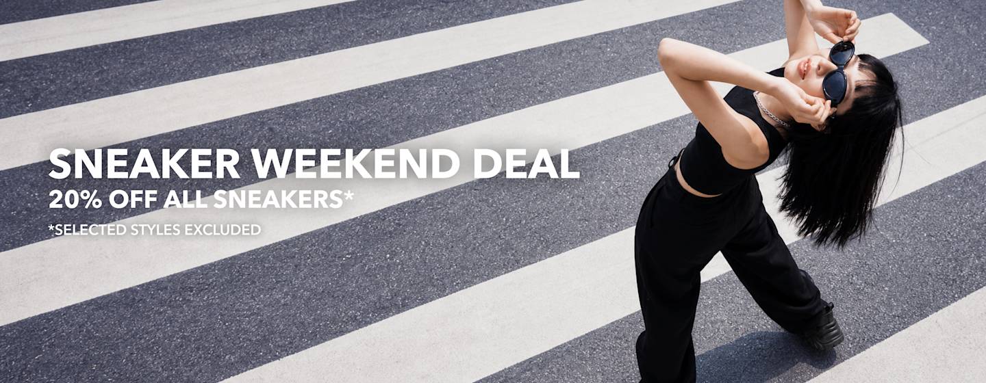 Person in black outfit posing on a zebra crossing during a sneaker promotion campaign.