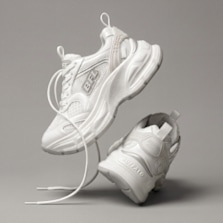 White chunky sneakers shown in a floating product shot against a neutral background.