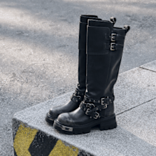 Black knee-high biker boots with buckles and chunky soles.